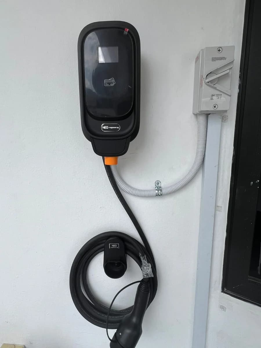 A black NEG charger with its supply run in white conduit to an isolator on the right.