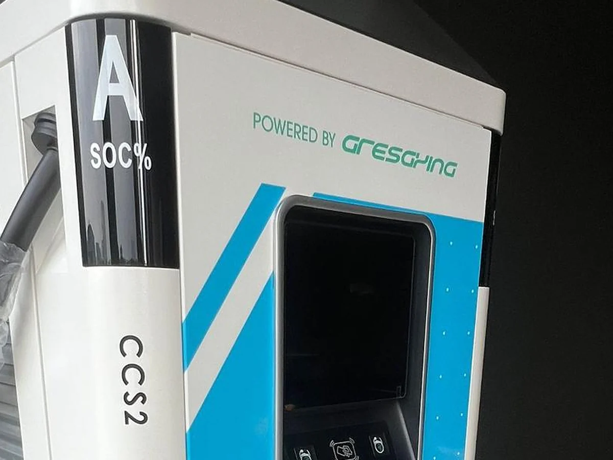A floor-standing DC fast charging cabinet with a colour touchscreen, a CCS2 outlet label and a state-of-charge display on its upper corner