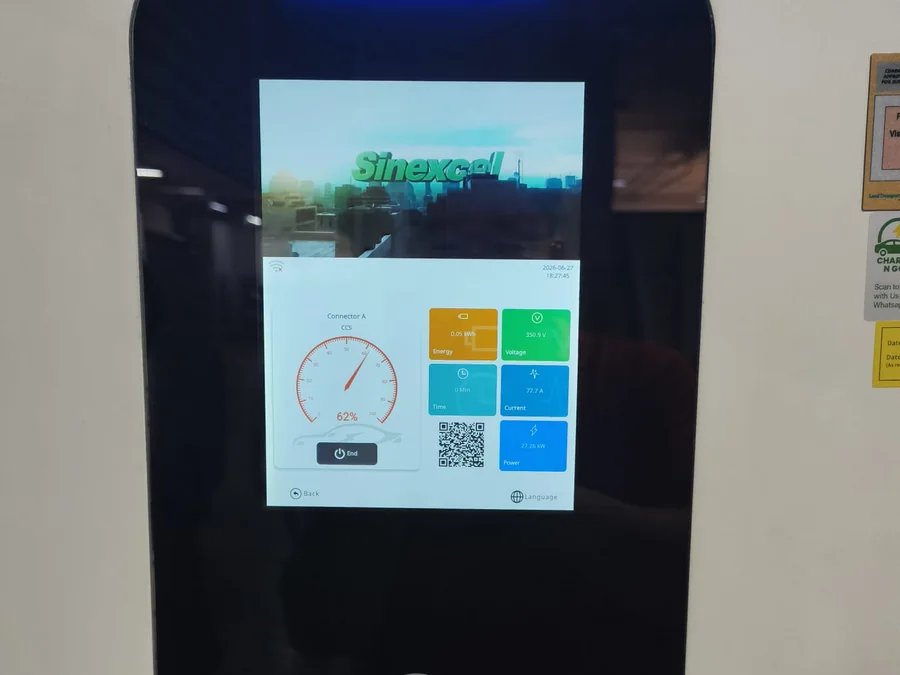 The colour touchscreen of a wall-mounted DC charging unit showing a live charging session